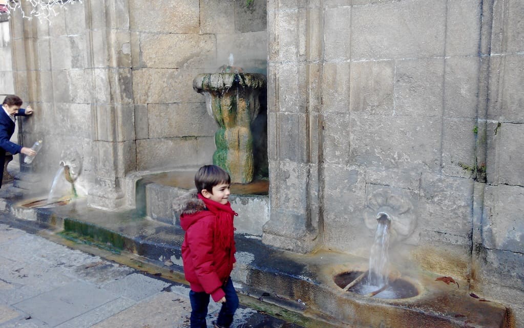 Niño frente a la fuente termal de As Burgas